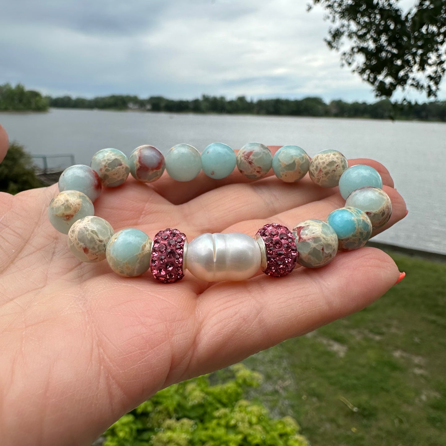 Add a touch of elegance and sparkle to your wrist with this stunning pale blue sediment Jasper and Freshwater Pearl Stretchy Bracelet, adorned with shimmering pink rhinestones for a touch of glamour