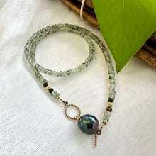 Load image into Gallery viewer, This necklace features a delicate chain of soft, translucent faceted green Prehnite rondelle beads, beautifully complemented by a striking Tahitian baroque pearl as the centerpiece pending from a cold filled toggle clasp. 18&quot;inches long
