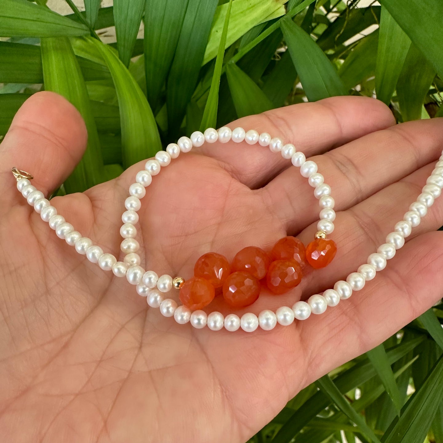 double wrap bracelet, featuring one long strand of lustrous freshwater pearls 4mm accented by stunning deep orange Carnelian Onion briolettes. Gold filled lobster clasp