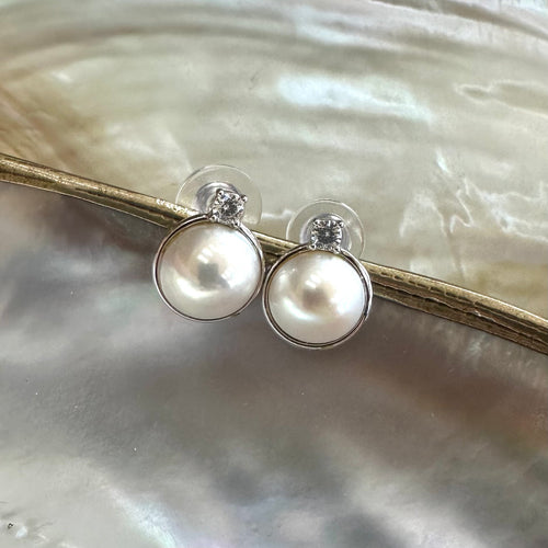 White Mabe Edison pearl stud earrings with CZ accents, set in sterling silver, minimalist and elegant, perfect for bridal jewelry or a special gift.