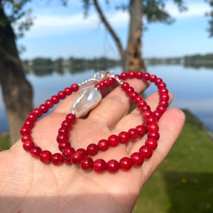 red coral and one large baroque pearl on the side of the necklace with sterling silver details, measuring 18 inches. This vibrant jewelry piece makes a thoughtful gift for her.