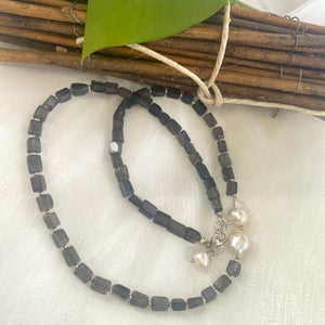 Navy Blue Iolite Rectangular Beads and 2 Baroque Pearls off centre Necklace. Finished with sterling silver details, this necklace brings together luxury and durability. The adjustable length, ranging from 19 to 20 inches, ensures a perfect fit